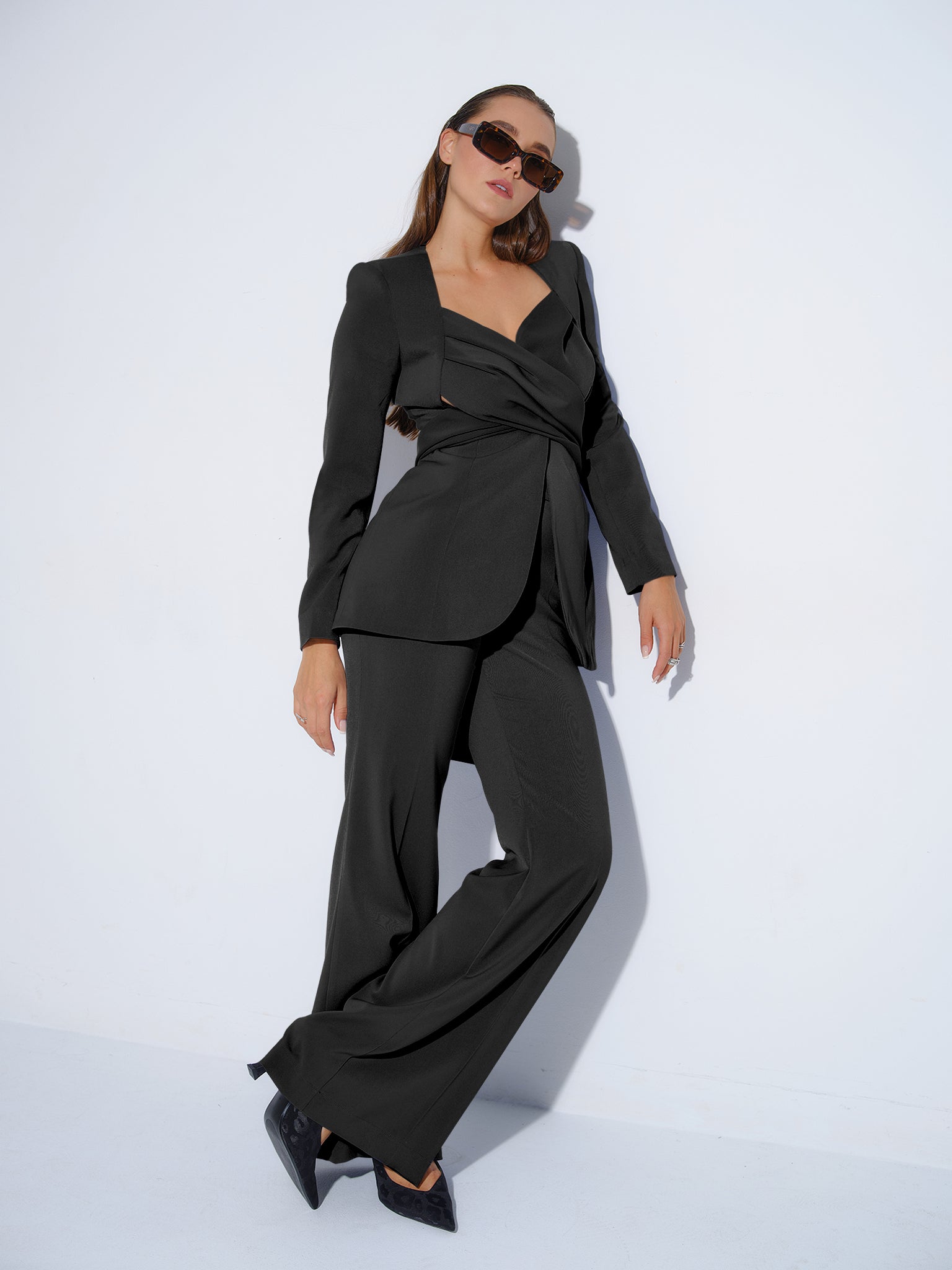 Tia Dorraine Magnetic Power Statement Cross Wrap Blazer This thigh-length design reimagines the classic blazer with a generous helping of creative flair. The piece features an impressive cross drape panels that create a sweetheart neckline when tied at th