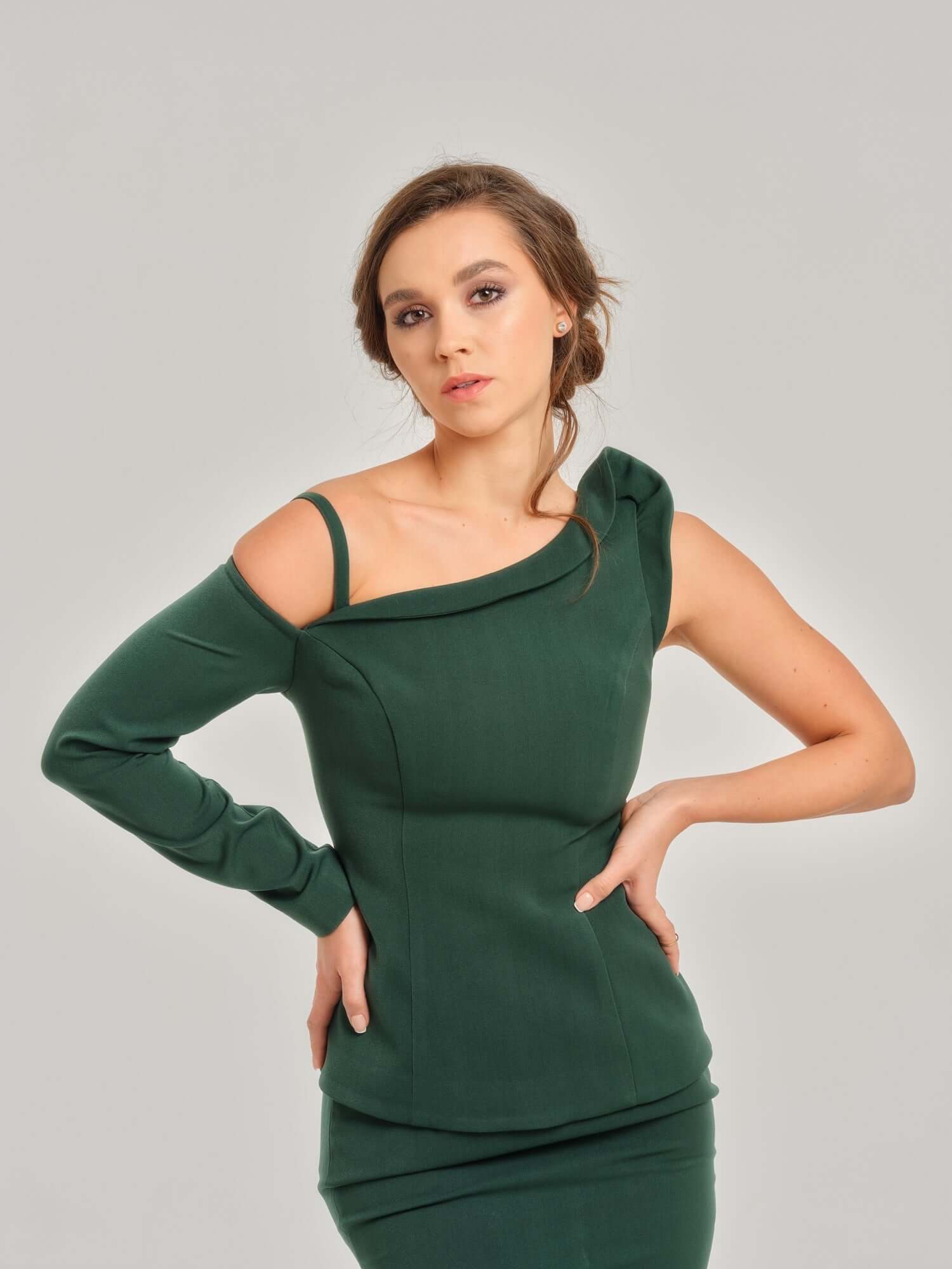 Tia Dorraine Emerald Dream Asymmetric One-Shoulder Top This incredible emerald green off-shoulder top has a single long sleeve with a tiny elegant strap, while the other shoulder includes an exciting drape going all the way across the front. Its waste-fit